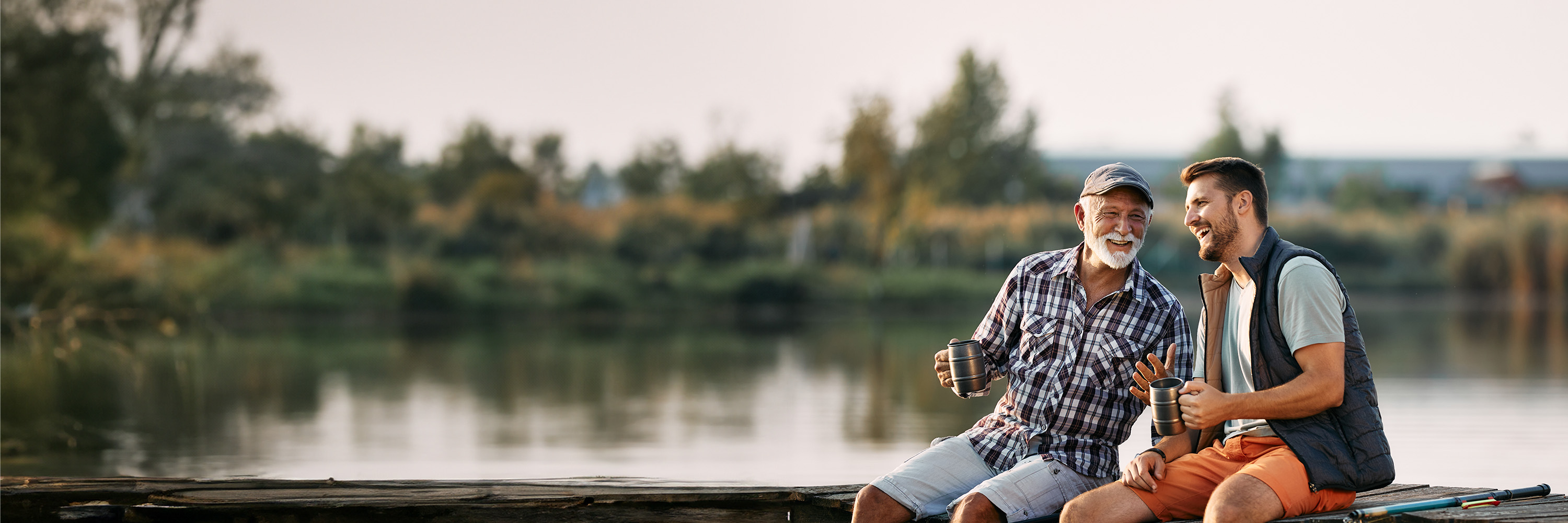 Father and son sitting on jetty