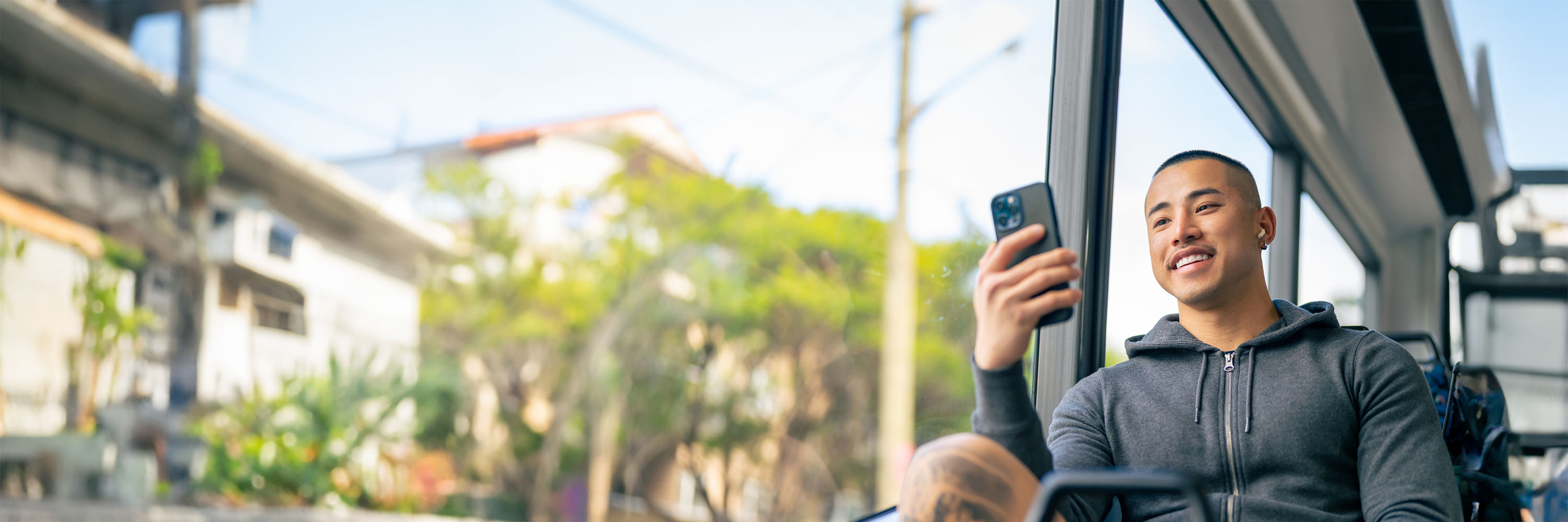 Young man on bus looking at phone
