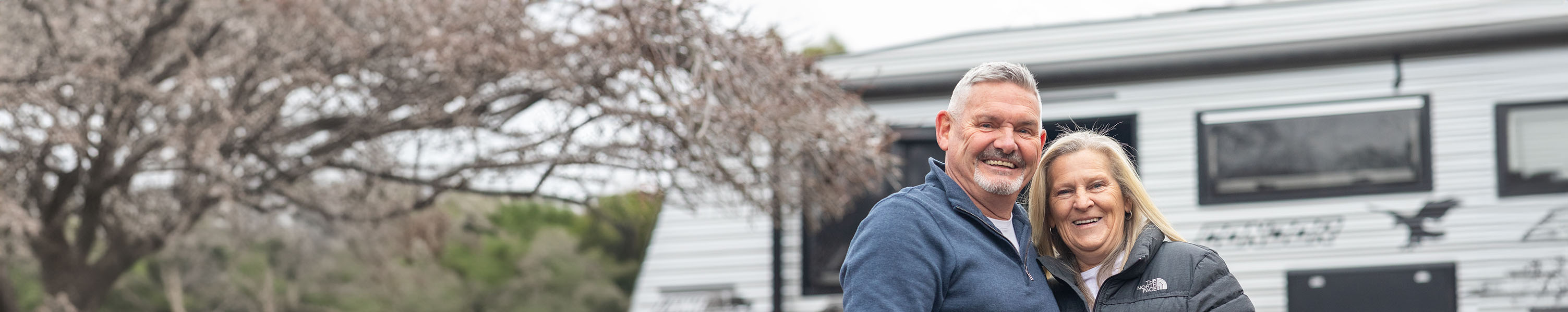 Man and woman standing in front of a white caravan