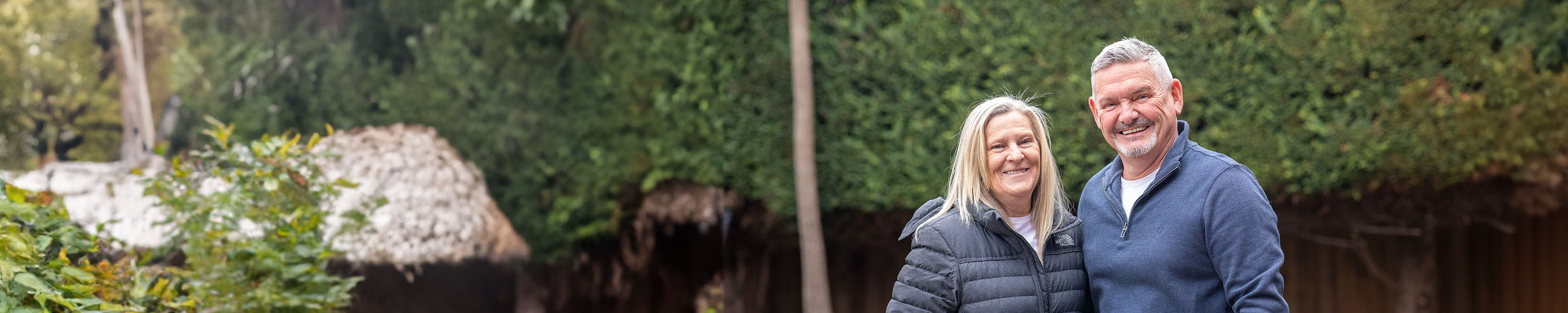 Man and woman standing together and smiling in a garden