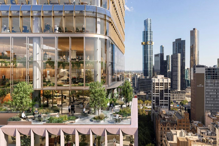Man in black tshirt sitting at  desk with computer monitors and keyboard