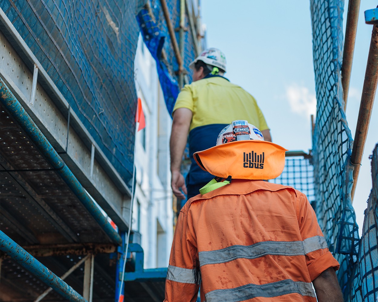 Two construction workers heading upstairs on a construction site