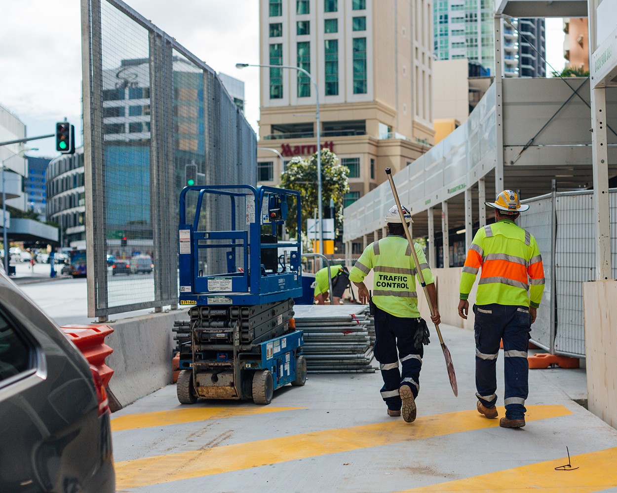 The back of two construction workers walking on a building site