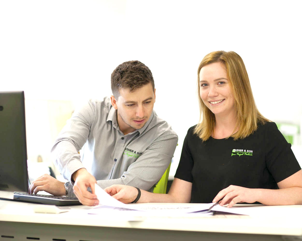 Male and female colleagues working at a desk and looking at documents 