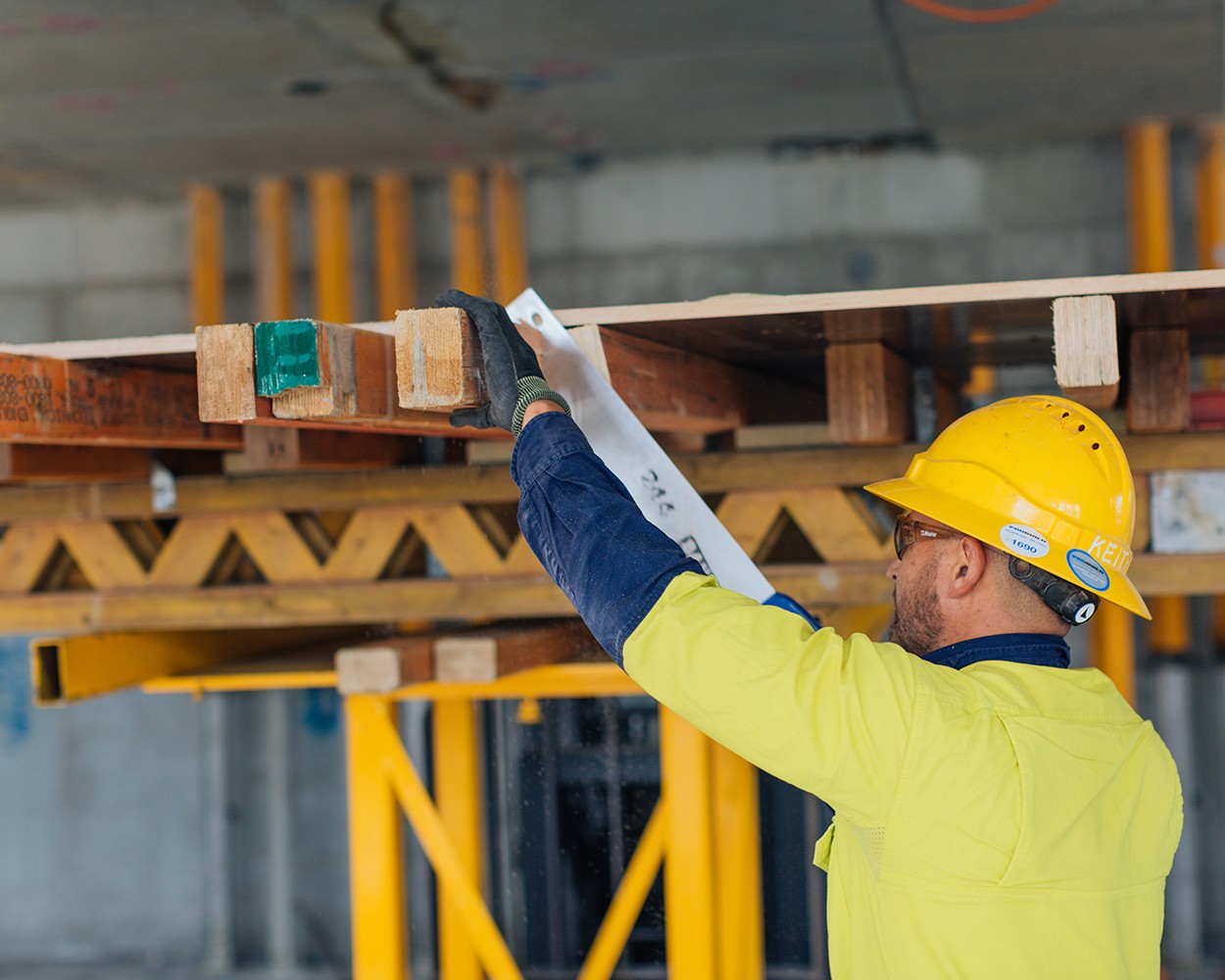 A construction worker sawing wood