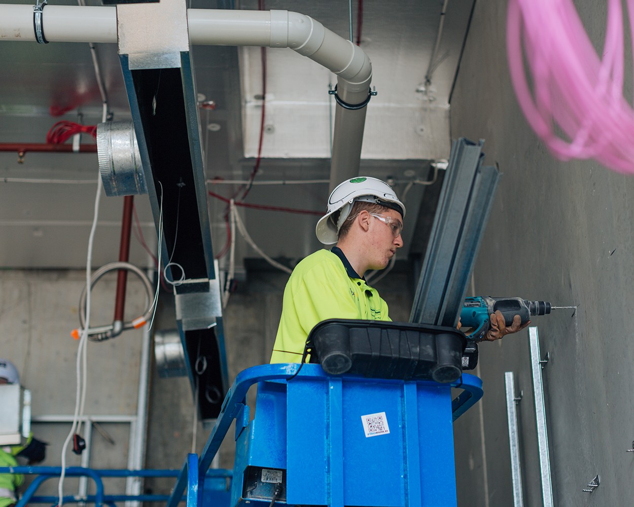 An electrician drilling holes in a wall