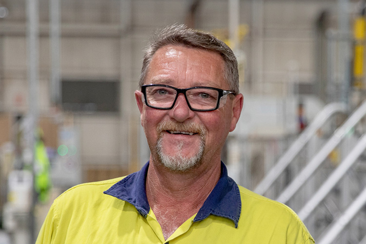 Older man on a construction site wearing yellow high visibility clothing 