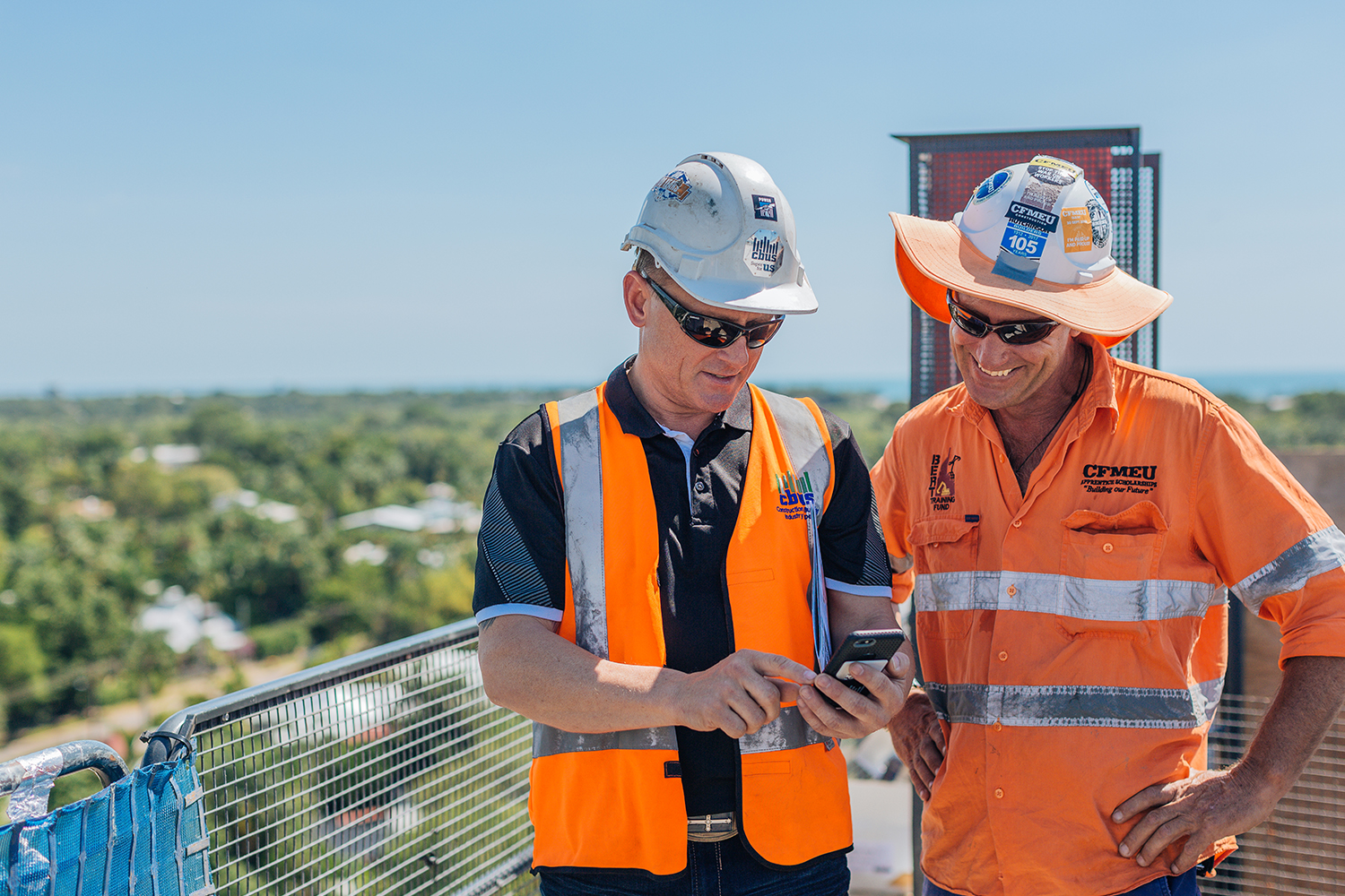 Two male tradies looking at phone