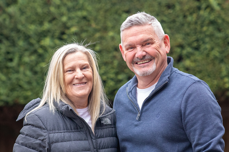 Older man sitting at a table next to three smaller children